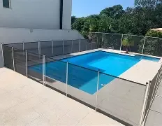 Quintal com piscina protegida por cerca de segurança ao entardecer