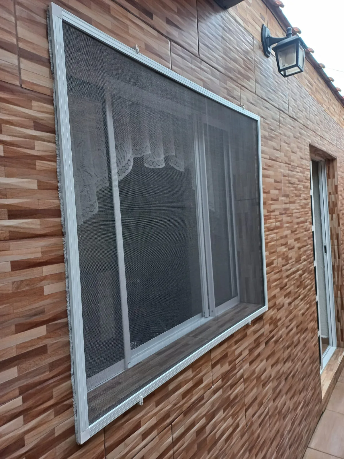 Tela mosquiteira retrátil em porta de sacada de sala